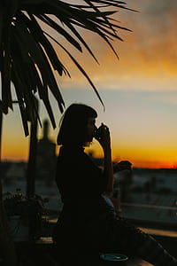woman drinking on cup during sunset thumbnail