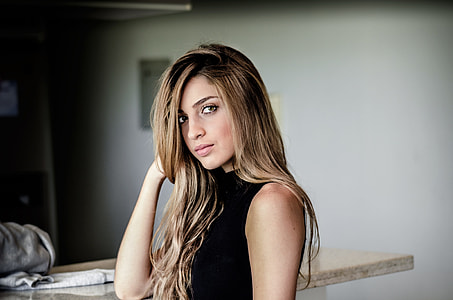 woman wearing in black sleeveless dress while looking at the picture thumbnail
