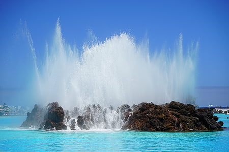 splash of water on brown islet during daytime thumbnail