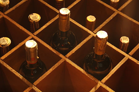 brown glass bottles in brown wooden rack thumbnail