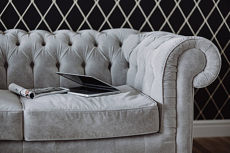 Elegant grey sofa with a laptop, an iPhone and a magazine thumbnail