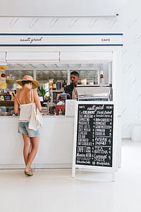 woman wearing brown sunhat paying at the Nauti Grind Cafe counter thumbnail