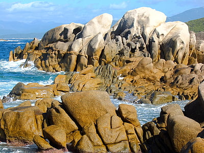 landscape photography of brown rock hill over body of water thumbnail