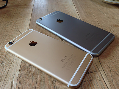 two gold and space gray iPhone 6' on brown wood thumbnail