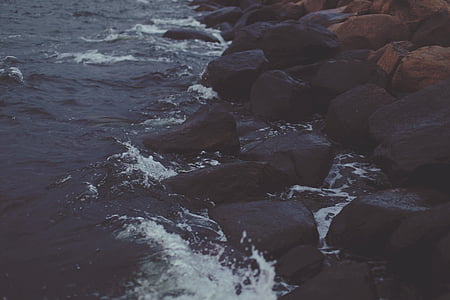 body of water beside rock formation during sunrise thumbnail