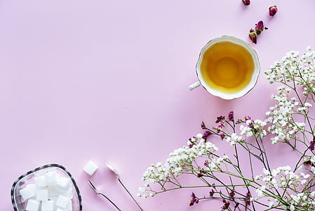 white ceramic cup near white and purple petaled flowers thumbnail