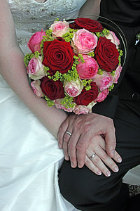 man holding woman's hand with red and pink floral rose bouquet thumbnail