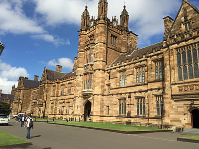 person wearing bag walking in front of tower thumbnail