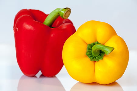 red and yellow peppers on white table thumbnail
