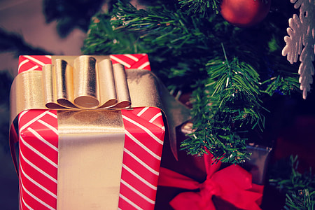 photo of red gift box near Christmas Tree thumbnail