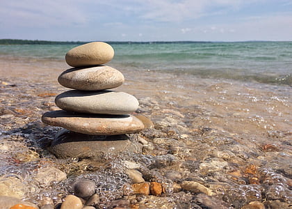 stacked stones near shoreline during daytime thumbnail