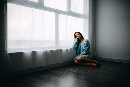 woman leaning on window near curtain thumbnail