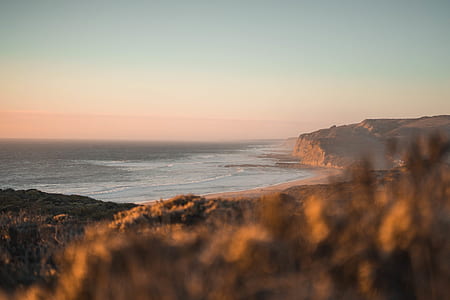 seashore near mountain at daytime thumbnail