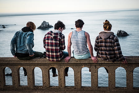 group of four people sitting on concrete bridge thumbnail