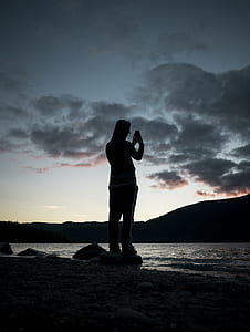 person standing on stone at seashore thumbnail