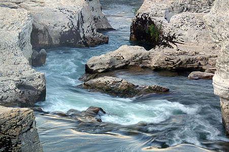 body of water in middle of rocks thumbnail