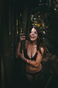 woman wearing bikini hugging bamboo grass thumbnail
