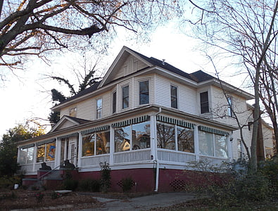 white and beige wooden house near bare trees thumbnail