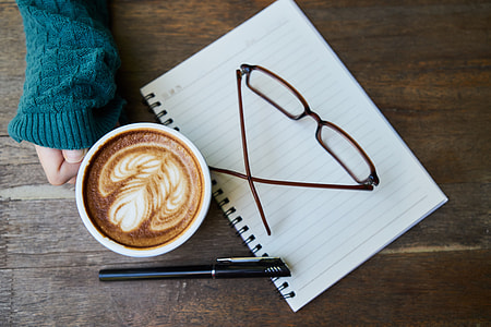 clear eyeglasses with brown and black frame on top of piece of white paper thumbnail