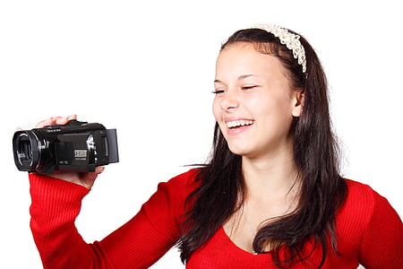 woman smiling while holding video camera thumbnail
