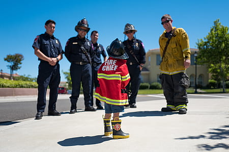 child in Fire Chief uniform standing in front of five men thumbnail