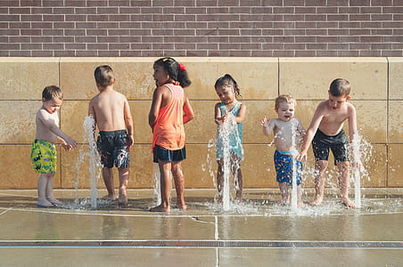 children playing near fountain outdoor during daytime thumbnail