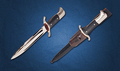 two silver and black dagger with sheath on top of blue surface thumbnail