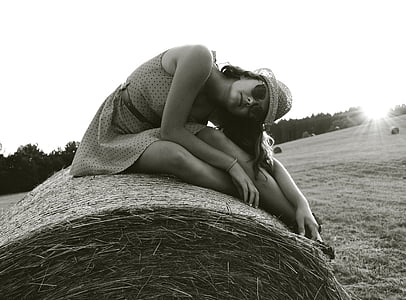grayscale photography of woman sitting on hay thumbnail