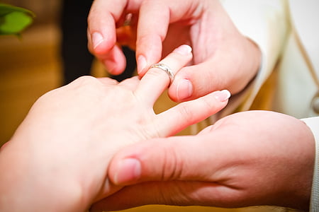 candid photography of man's hand wearing bridal ring on woman's finger thumbnail