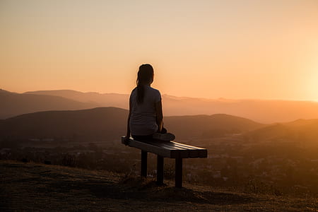woman sitting on bench looking at city thumbnail