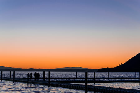 four person on dock during sunset thumbnail