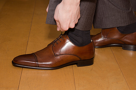 person wearing pair of brown leather dress shoes thumbnail