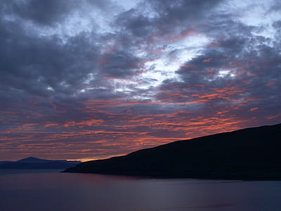 Landscape Photography of Black Rocky Formation With Orange Horizon Under Blue Clouds thumbnail