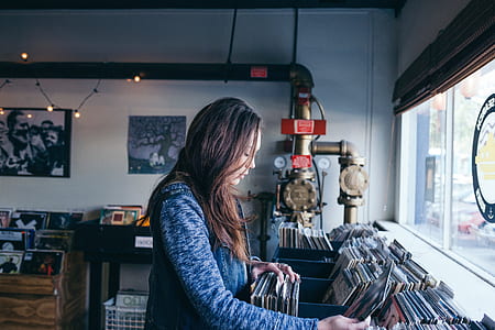 woman standing in front of vinyl sleeves thumbnail