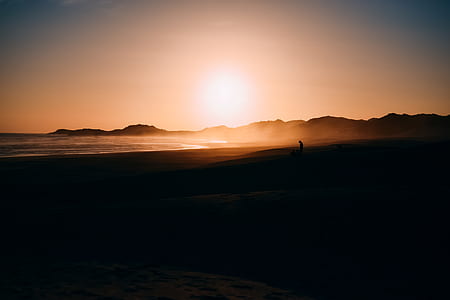 silhouette of man standing near sea during sunset thumbnail