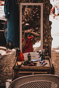 selective focus photography of bottles and brush on dresser with mirror thumbnail