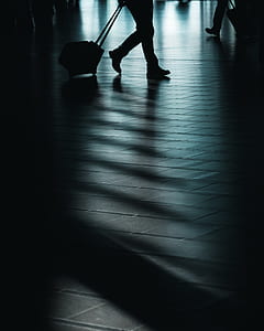 silhouette photography of man with trolley bag thumbnail