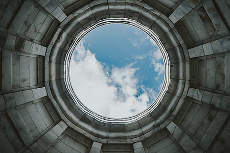 round concrete building with hole under blue sky during daytime thumbnail