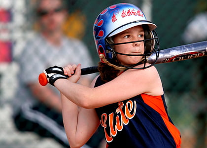 girl playing baseball during daytime thumbnail