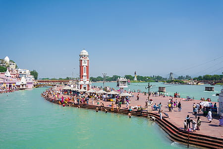 roup of people near brown concrete tower under clear blue sky thumbnail