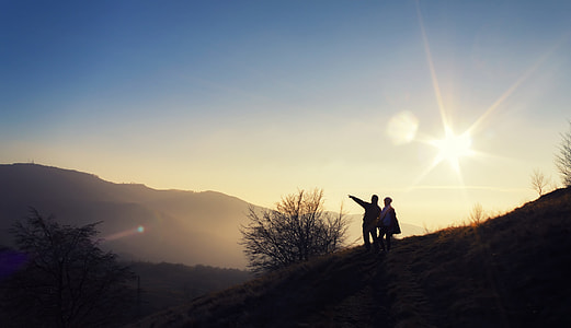 silhouette of two person standing on mountain during daytime thumbnail