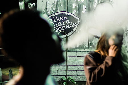 selective focus photography of man blowing smoke thumbnail