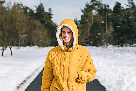 man wearing jacket walking on road during winter time thumbnail