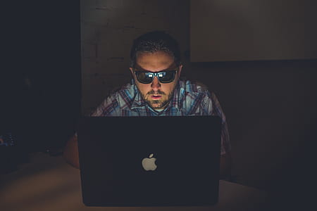 man wearing sunglasses in front of MacBook inside room thumbnail