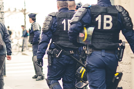 1B police unit men near brown building during daytime thumbnail