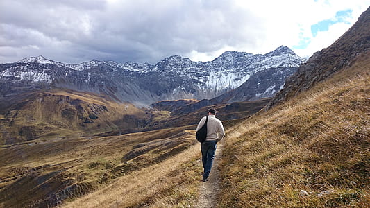 person walking on pathway between grasses thumbnail