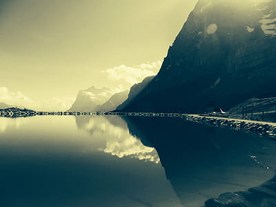 landscape photography of calm body of water nearby mountains thumbnail