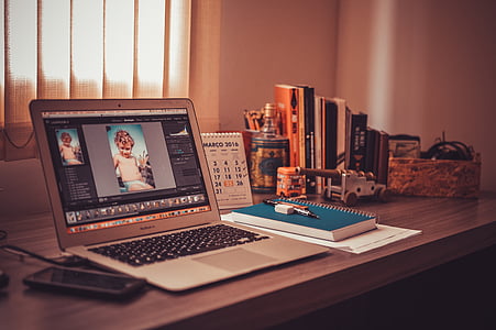 MacBook Air on table beside smartphone and books thumbnail
