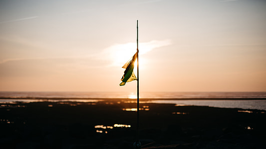 flag on pole during sunset thumbnail