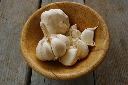 white garlic on brown wooden bowl thumbnail